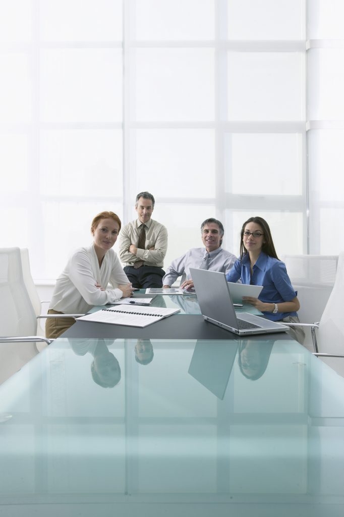 Group of Businesspeople Sitting at Conference Table --- Image by © Larry Williams & Associates/zefa/Corbis